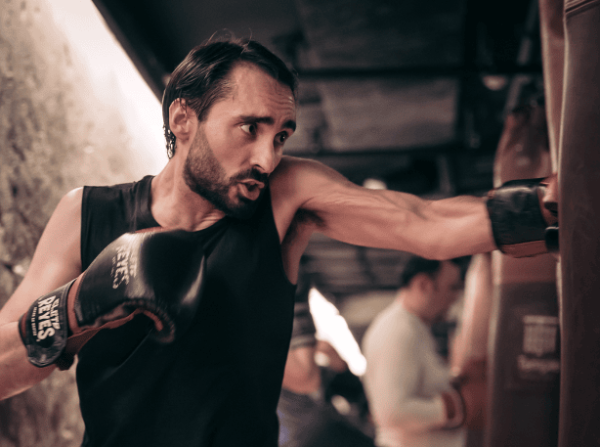 Boxeur frappant dans un sac en étant protégé par ses bandes de boxe.