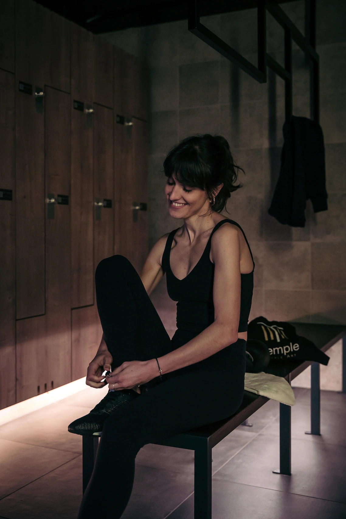 Boxeuse se changeant dans les vestiaires du Temple | Noble Art, club de boxe à Paris